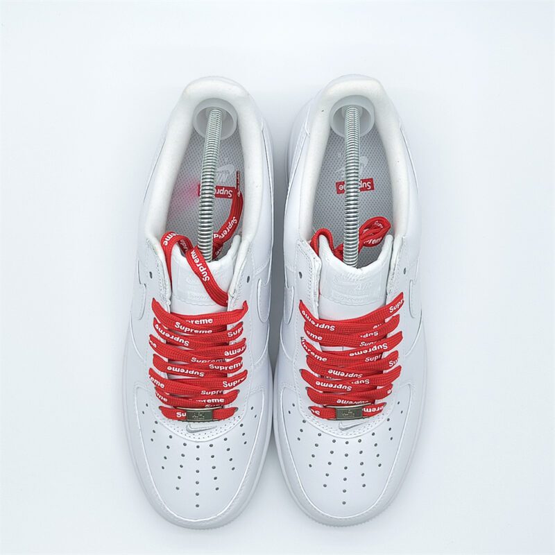 Top-down view of Supreme Air Force 1 White sneakers featuring red Supreme logo shoelaces and premium leather