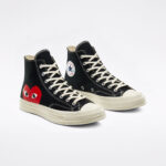 Pair of CDG Play Converse High Top Black sneakers featuring black canvas uppers, red heart logos, white laces, and vintage-inspired rubber midsoles.