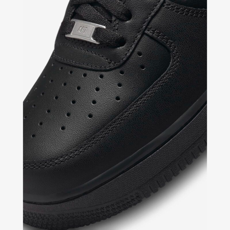 Close-up of Nike Air Force 1 Low Black perforated toe box with premium leather texture and AF1 lace dubrae.