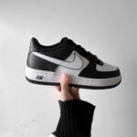 Nike Air Force 1 Low Panda DV0788-001 held in hand displaying side profile, leather materials, and black white colorway.