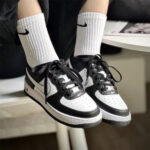 Nike Air Force 1 Panda worn with black pants and white Nike socks in a casual streetwear outfit.