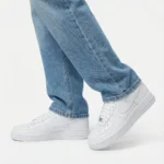 Nike Air Force 1 Low Triple White worn with blue denim jeans for a clean casual streetwear outfit.
