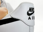 Close-up of Nike Air Force 1 Low White Black heel area featuring embroidered Nike Air logo and leather construction.