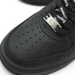 Close-up of Supreme Black Air Force 1 perforated toe box with AF1 lace dubrae and premium leather texture.