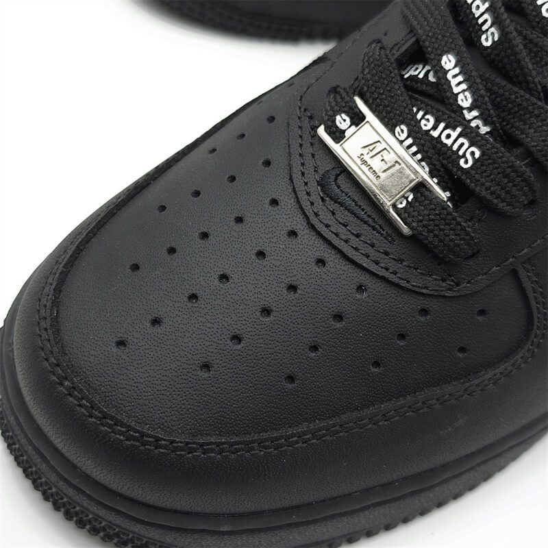 Close-up of Supreme Black Air Force 1 perforated toe box with AF1 lace dubrae and premium leather texture.