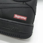 Close-up of Supreme Box Logo on Supreme x Nike Air Force 1 Low Black showcasing the iconic red branding against black leather.