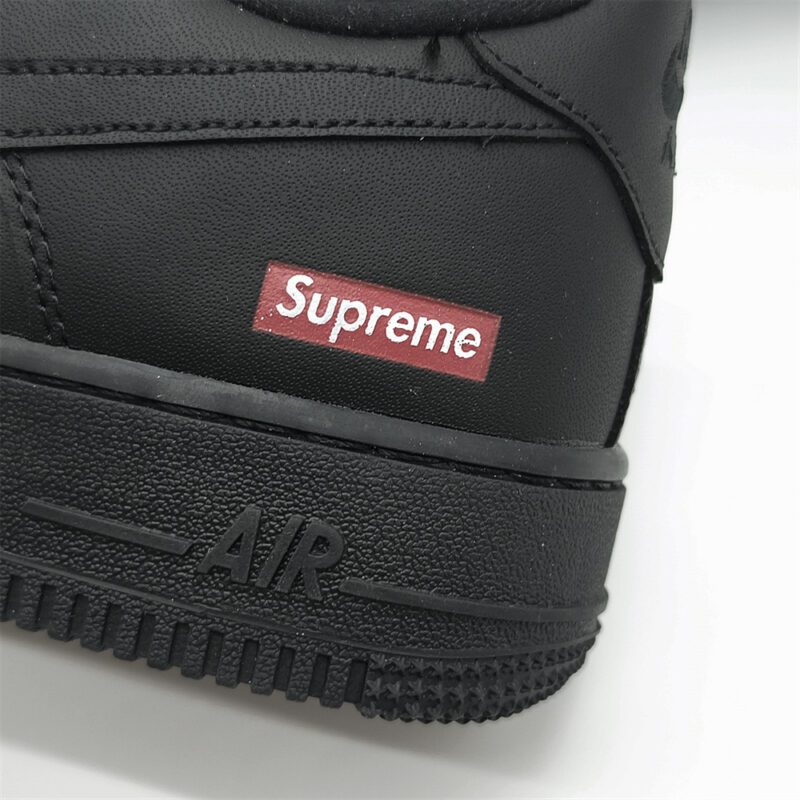 Close-up of Supreme Box Logo on Supreme x Nike Air Force 1 Low Black showcasing the iconic red branding against black leather.