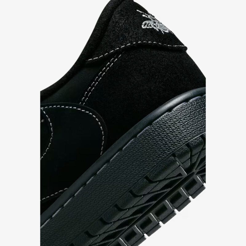 Close-up of the Travis Scott Jordan 1 Low Black Phantom heel featuring premium black suede, embroidered Wings logo, and textured rubber midsole.