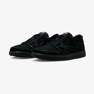 Travis Scott Jordan 1 Low Black Phantom sneakers shown in a front three-quarter view, featuring premium black suede, reverse Swoosh, white contrast stitching, and an all-black sole.