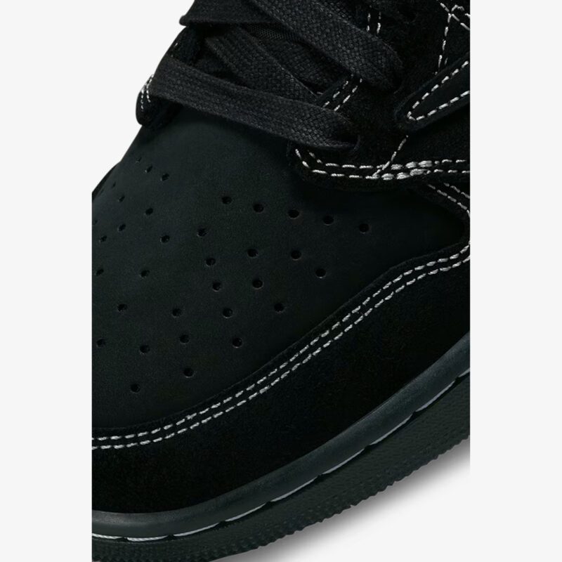 Close-up of the Travis Scott Jordan 1 Low Black Phantom toe box showing premium nubuck leather, perforations, suede overlays, and white contrast stitching.