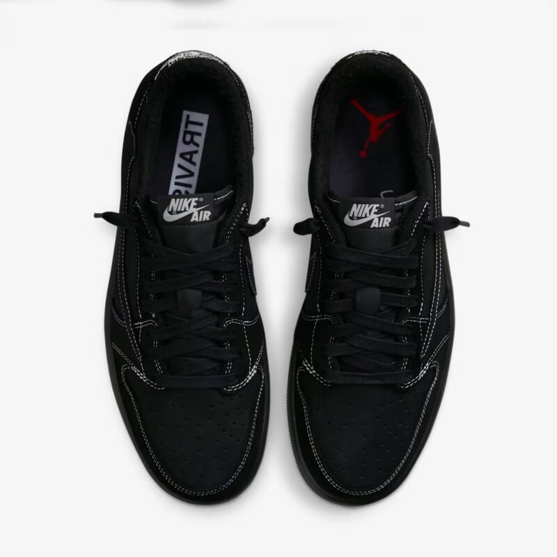 Top-down view of the Travis Scott Jordan 1 Low Black Phantom showing perforated toe box, black laces, Nike Air tongue labels, and premium interior branding.