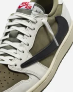 Close-up of the reverse black leather Swoosh on the Travis Scott Air Jordan 1 Low Medium Olive with premium stitching.